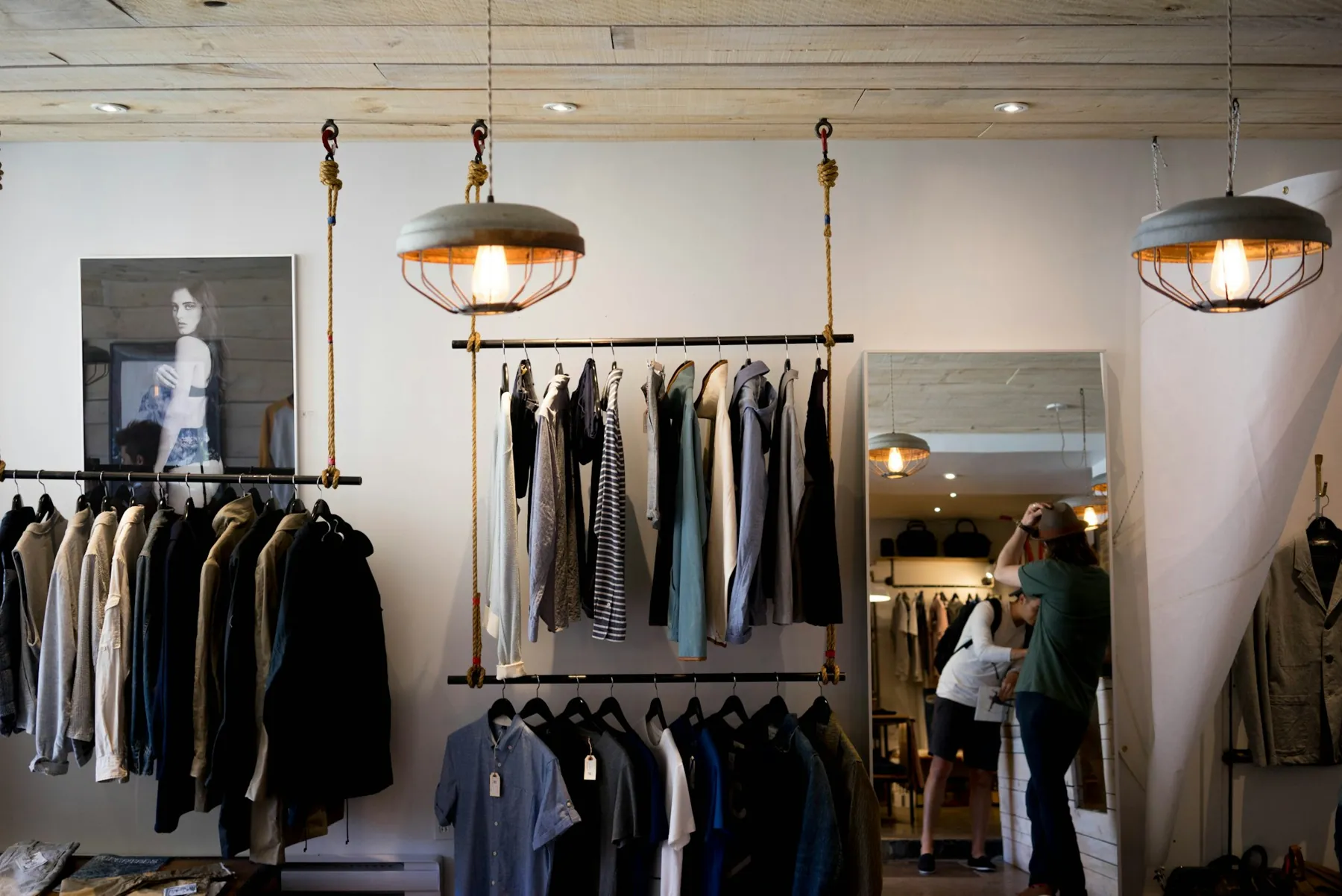 Clothing on hanging racks in a boutique.